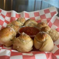 Garlic Knots · Dough tied into knots, and oven baked topped with garlic butter, and served with marinara.