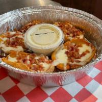 Giant Bacon And Cheese Potato Skins · Potato skins topped with bacon and mozzarella. Served with ranch.