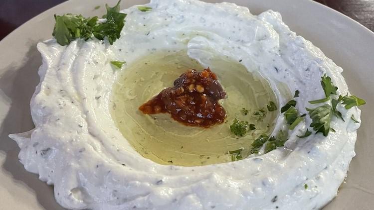 Labneh Appetizer · Lebanese sour cream mixed with fresh mint and garlic, topped with olive oil.
