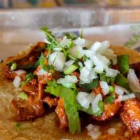 Street Taco Al Pastor · Marinated pork served in a corn tortilla topped with onions and cilantro.