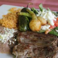 Carne Asada · Marinated charbroiled skirt steak. Served with a side of rice, refried beans, side salad (le...