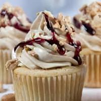 Peanut Butter Jelly Cupcake · Vanilla cake filled with grape preserves, frosted with a peanut butter frosting and topped o...