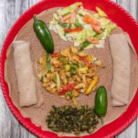 Chicken Tibs · Boneless chicken seasoned with Ethiopian spices sautéed with onion, tomato, and peppers topp...