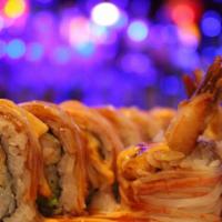 Dynamite Roll · Shrimp tempura and avocado inside,  topped with crab stick, spicy mayo and eel sauce.