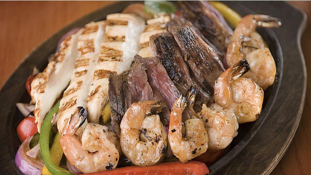 Fajitas · Your choice of protein, sizzling with onions, tomatoes & bell peppers with lettuce, tomato, sour cream, guacamole, & corn, flour or wheat tortillas; served with rice & your choice of charro or refried beans.