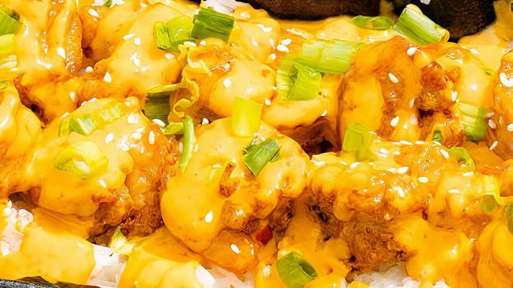 Boom Boom Shrimp · Tender, crispy shrimp tossed in a light creamy, but spicy sauce served over rice. With scallions and sesame seeds.