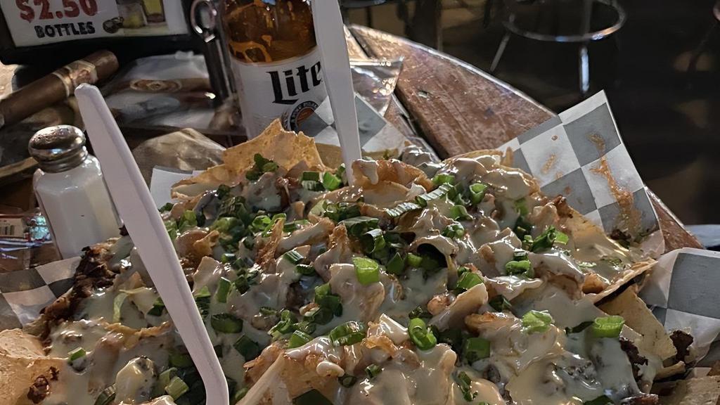 Ultimate Nachos · Beef or chicken, shredded cheeses, aioli chipotle sauce, onion rings, bacon, hot peppers and sour cream served on a pile of fresh tortilla chips.