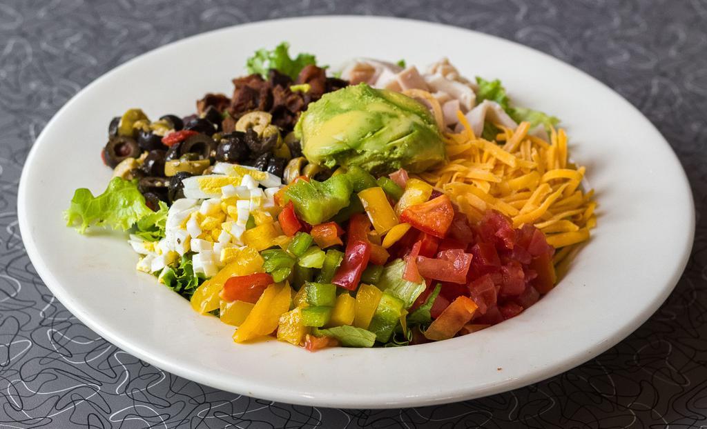 Cobb Salad · Turkey breast, bacon, cheddar cheese, tomato, olive salad, hard-boiled egg, peppers and avocado on a bed of mixed greens with your favorite dressing.