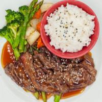 Steak Teriyaki · Grilled steak slices drizzled with teriyaki sauce sesame seeds and served with a side of veg...