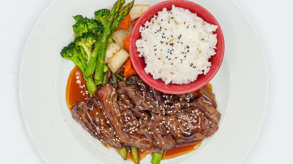Steak Teriyaki · Grilled steak slices drizzled with teriyaki sauce sesame seeds and served with a side of vegetables.
