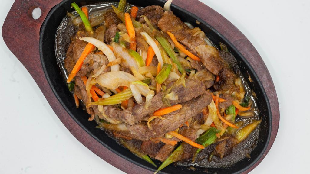 Sizzling Beef · New york strip sliced sauteed and stir-fried with carrots celery onions scallions and mushrooms in a delicious sauce.
