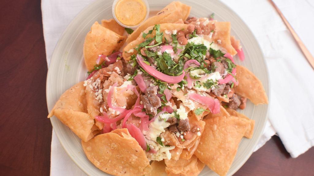 Mexa-Nachos · Queso fresco, Mexican crema, sweet-tangy pickled red onions, cilantro, and sirloin.