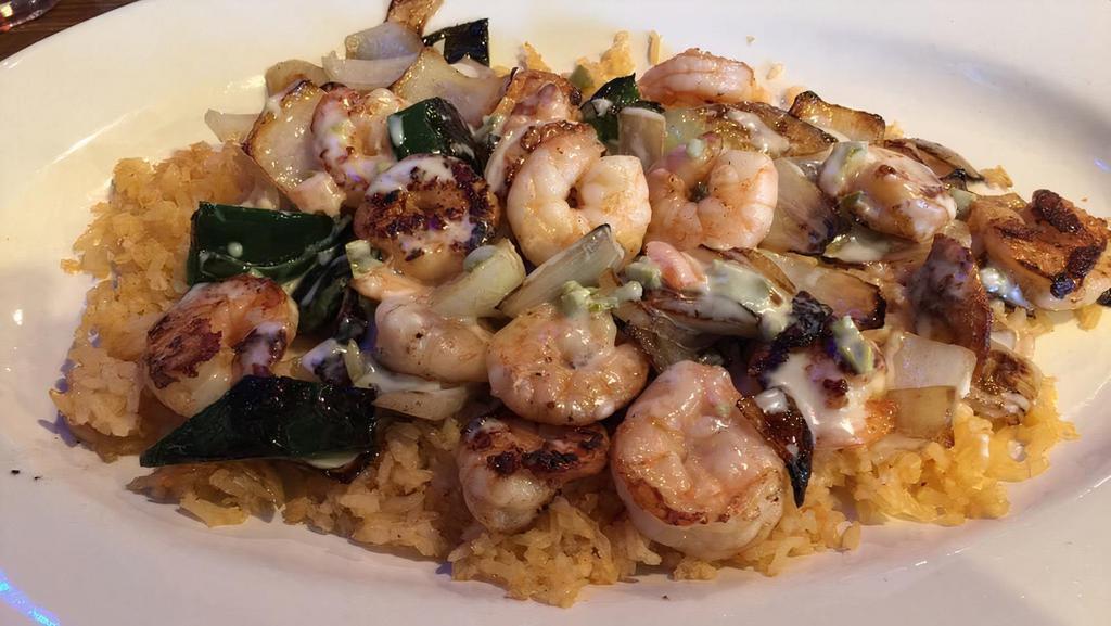 Arroz Con Camaron · Tender shrimp grilled with mushrooms, onions, and poblano pepper, served on a bed of rice and cheese.