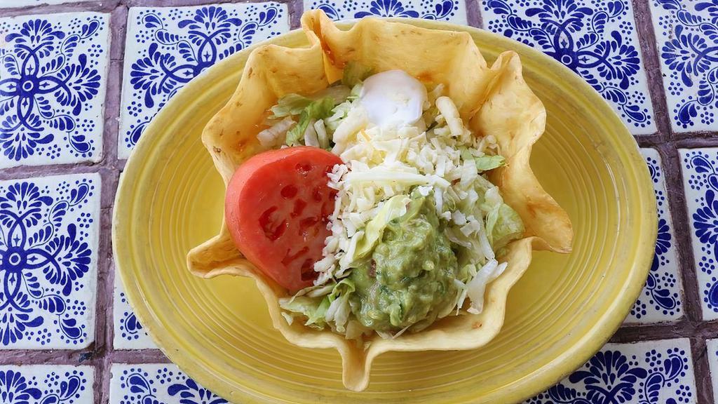 Taco Salad · Crispy taco bowl shell filled with your choice of juicy shredded chicken, fresh ground beef, or tender chunk beef topped with lettuce, cheese, guacamole, sour cream, and tomatoes.