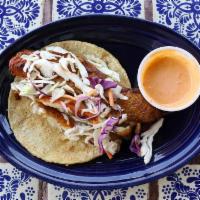 Fish Taco · Corn tortilla filled with grilled Pangasius dressed with cabbage and a homemade fish sauce.