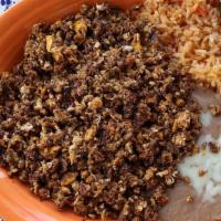 Huevo Con Chorizo · A scramble of chorizo and eggs with a side of fresh rice, homemade refried beans, and your c...