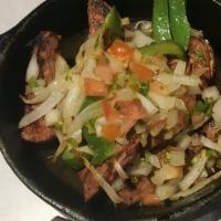 Fajitas · Strips of marinated meat charbroiled on our grill. Served with pico de gallo, smothered onio...