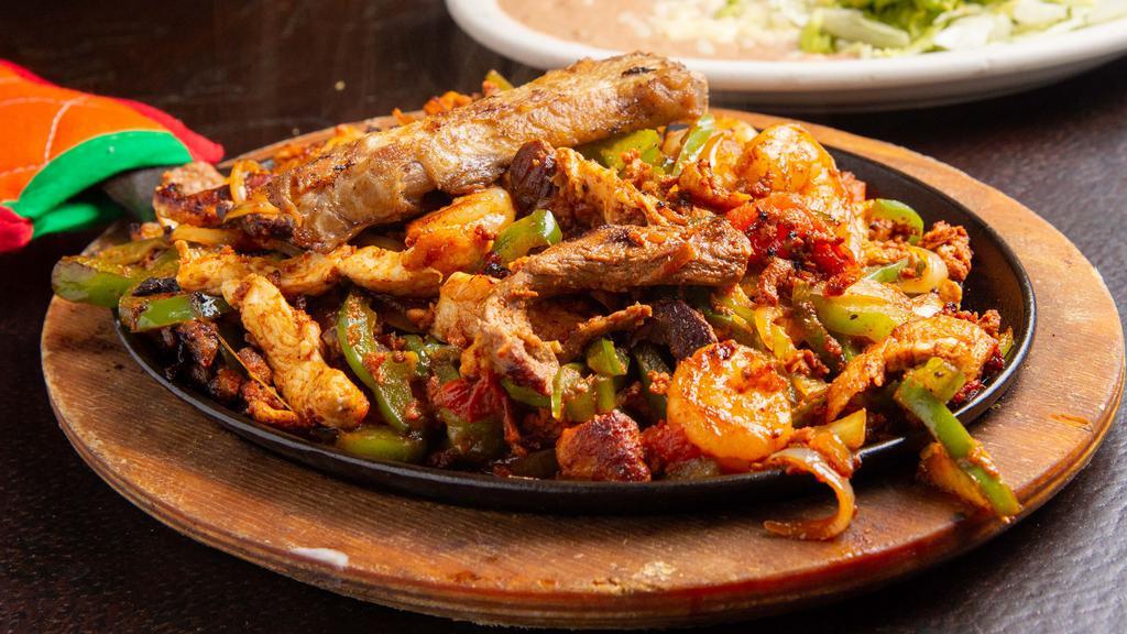 Fajitas · Tender strips of marinated chicken breast, steak or mixed. Cooked with sautéed onions bell peppers and tomatoes. Served served with salad, rice and bean.