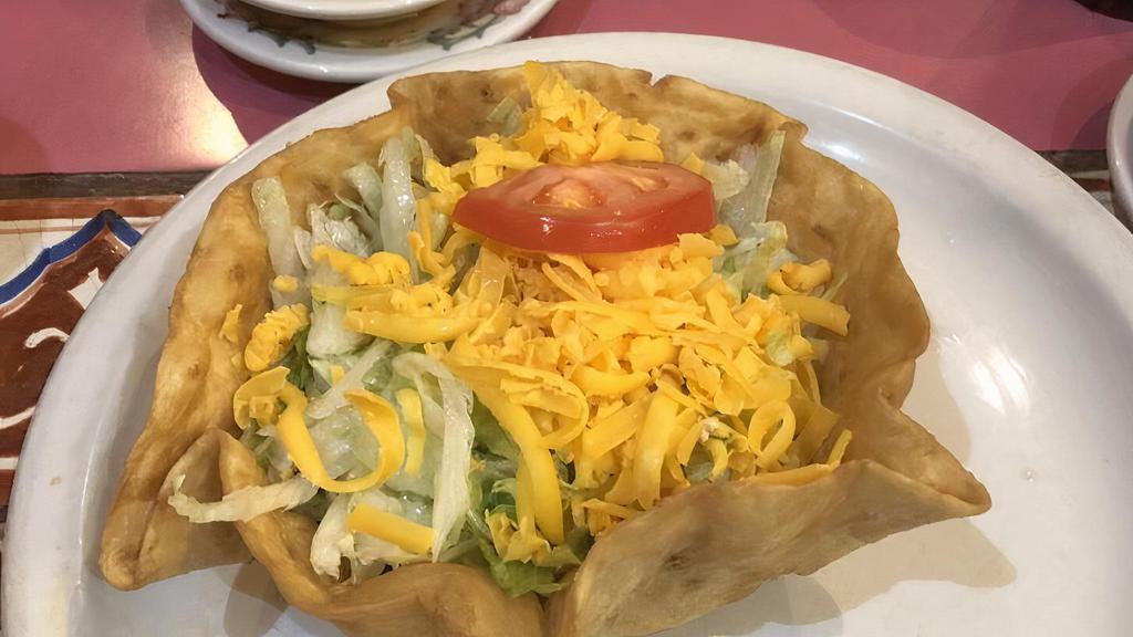 Taco Salad · Traditional taco salad is served on a crispy flour tortilla shell with choice of chicken or beef, lettuce, cheese, and tomato.