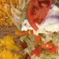 Deluxe Burrito · A flour tortilla filled with your choice of chicken or beef. Topped with baked cheese, lettu...