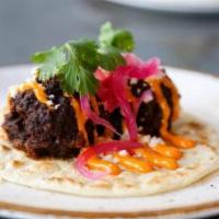 Albondigas Taco · Aaron's grandmother's meatballs, chipotle, queso fresco, pickled onion served on a warm flou...