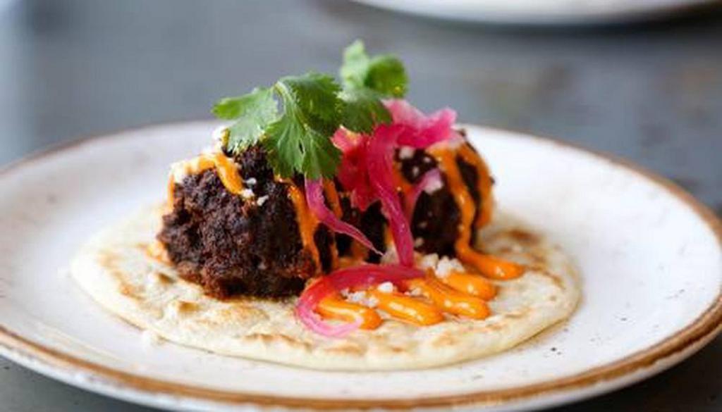 Albondigas Taco · Aaron's grandmother's meatballs, chipotle, queso fresco, pickled onion served on a warm flour tortilla