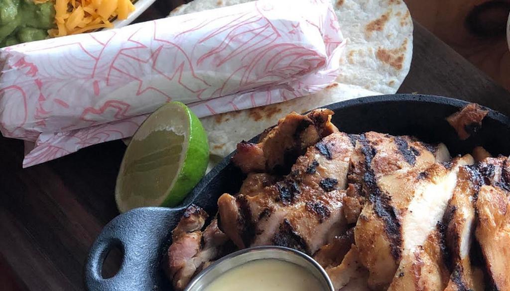 Chicken Fajitas · served over poblanos and onions with pico de gallo, guacamole, sour cream, queso, jalapenos, and warm flour tortillas. Served with mexican rice and black beans.