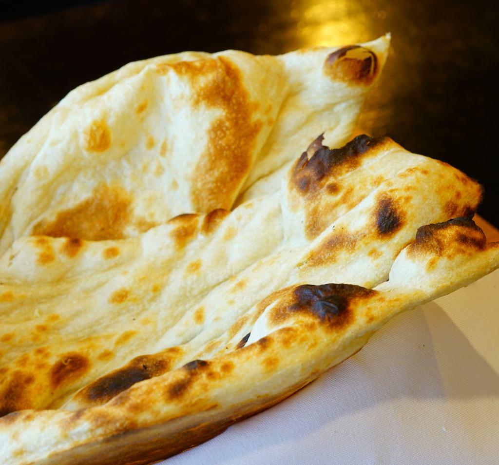 Naan · Tandoor oven-baked flatbread.