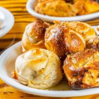 Garlic Knots · Serving of 6 oven baked pizza dough knots glazed with seasoned garlic butter.