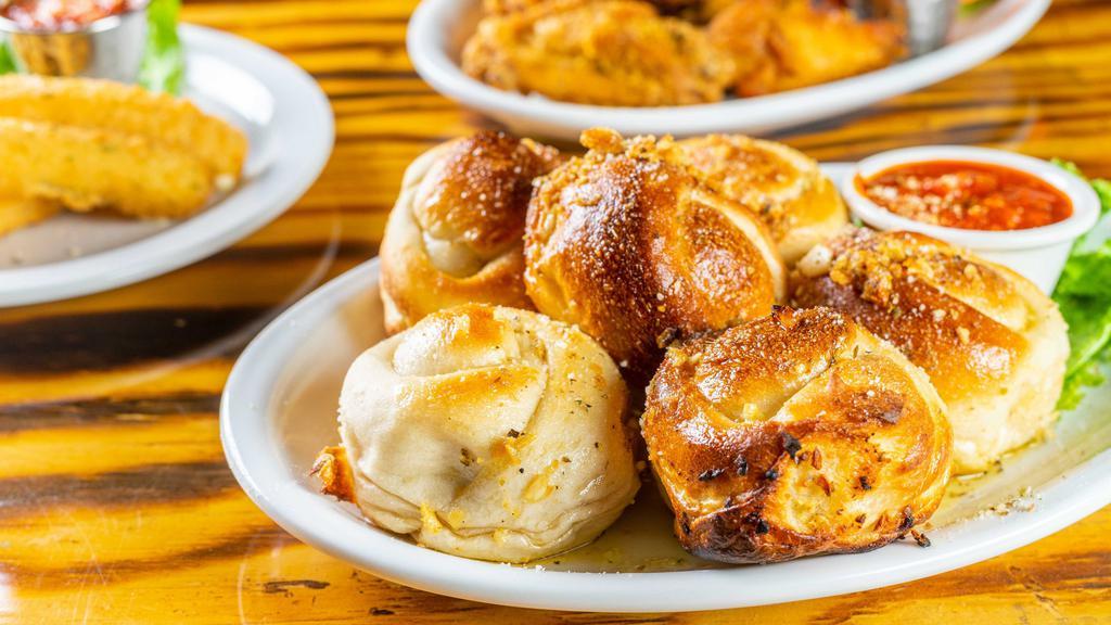 Garlic Knots · Serving of 6 oven baked pizza dough knots glazed with seasoned garlic butter.