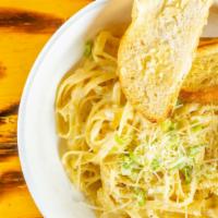 Fettuccine Alfredo · Fettuccine noodles tossed in a rich creamy alfredo sauce topped with chives and parmesan che...