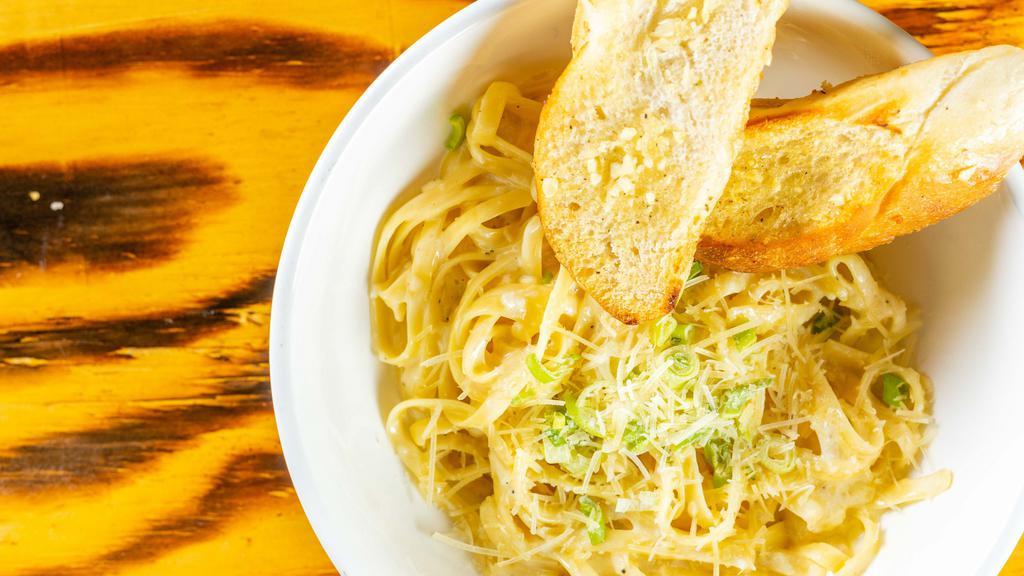 Fettuccine Alfredo · Fettuccine noodles tossed in a rich creamy alfredo sauce topped with chives and parmesan cheese.