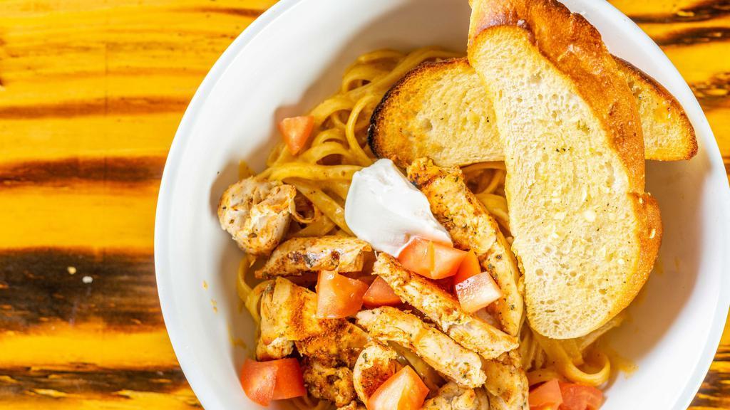 Cajun Cream Chicken Pasta · Grilled or blackened chicken on top of a bed of fettuccine noodles, topped with diced tomatoes, chives, and sour cream.