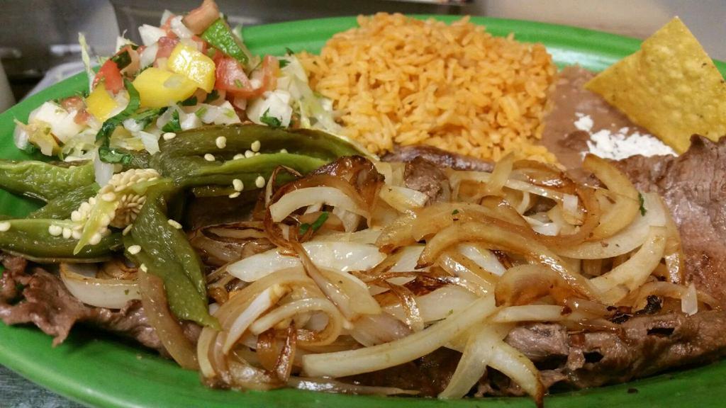 Bistec Asado Encebollado · Steak with grilled onions and chiles toreados.