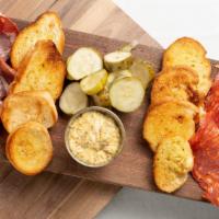 Charcuterie Board To Go · Selection of local and imported cured meats served with Doux South (Charleston) “angry cukes...
