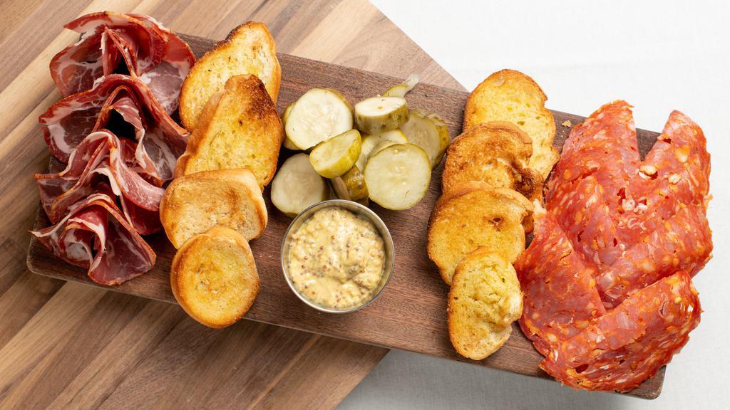 Charcuterie Board To Go · Selection of local and imported cured meats served with Doux South (Charleston) “angry cukes” pickles, Lusty Monk Mustard (Asheville) and locally baked bread.