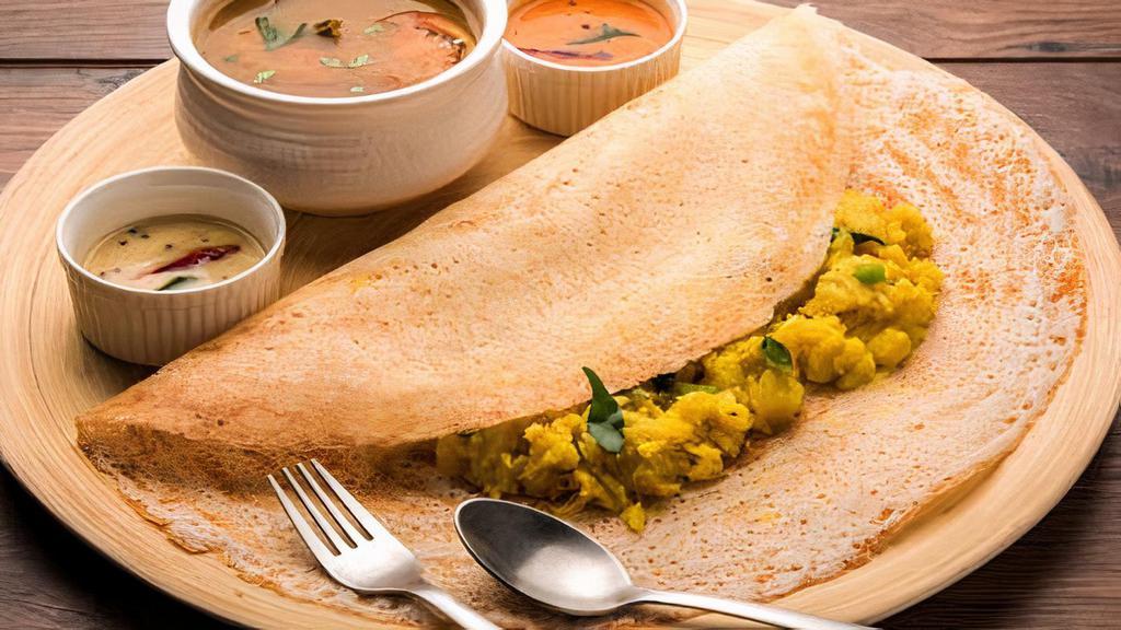 Masala Dosa (V) · Dosa served with potato curry, lentil soup, and coconut and tomato chutney.
