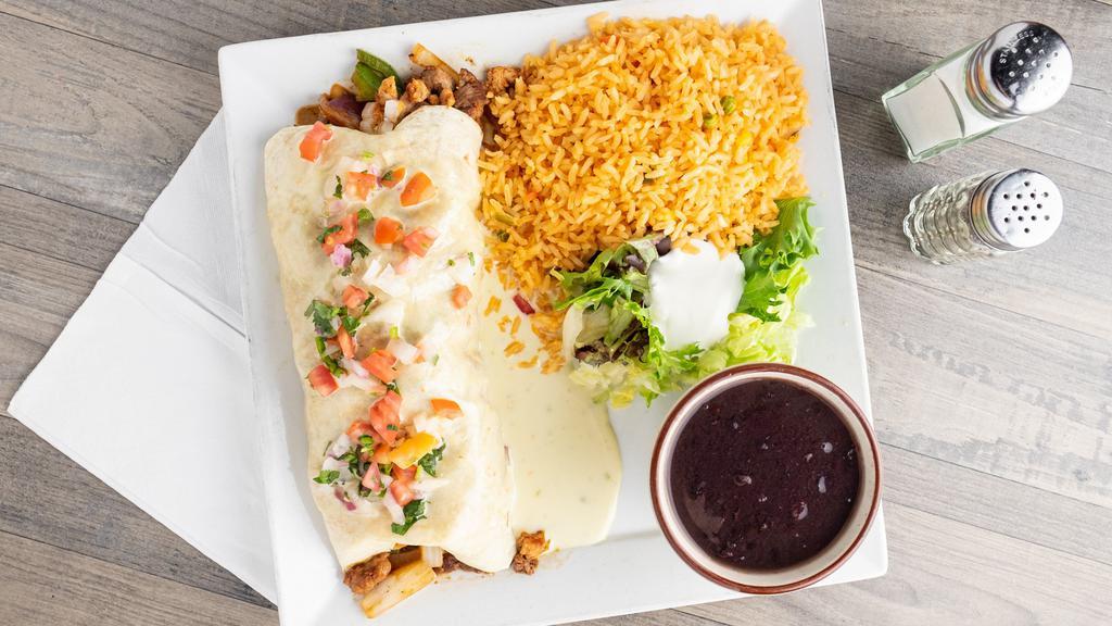 El Grande Burrito · Fajita chicken & steak, Mexican rice, cheese, black beans, caramelized onions & peppers topped with melted Jack cheese, served with a side of rice.