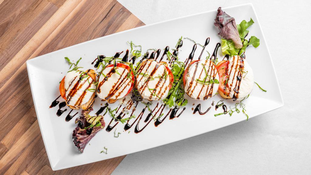 Mozzarella Caprese · Gluten-free. Fresh mozzarella, tomatoes, basil, and olive oil. Served on sliced bread and finished with a balsamic glaze.