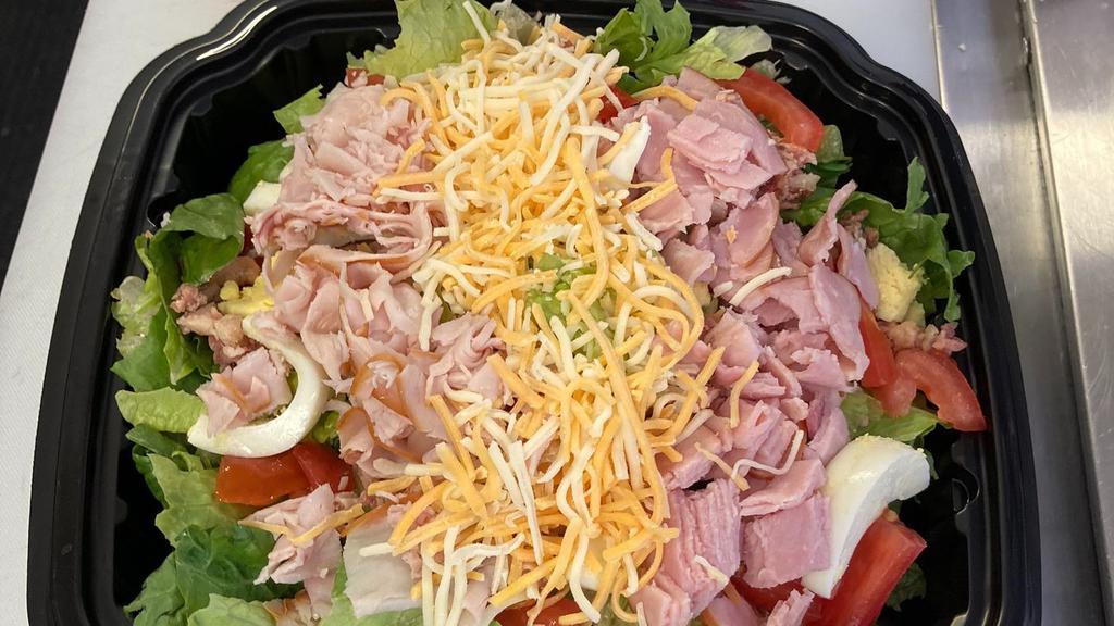 Chef Salad · Bed of romaine lettuce topped with tomatoes, eggs, ham, and turkey with blended cheeses. Served with Ranch dressing.