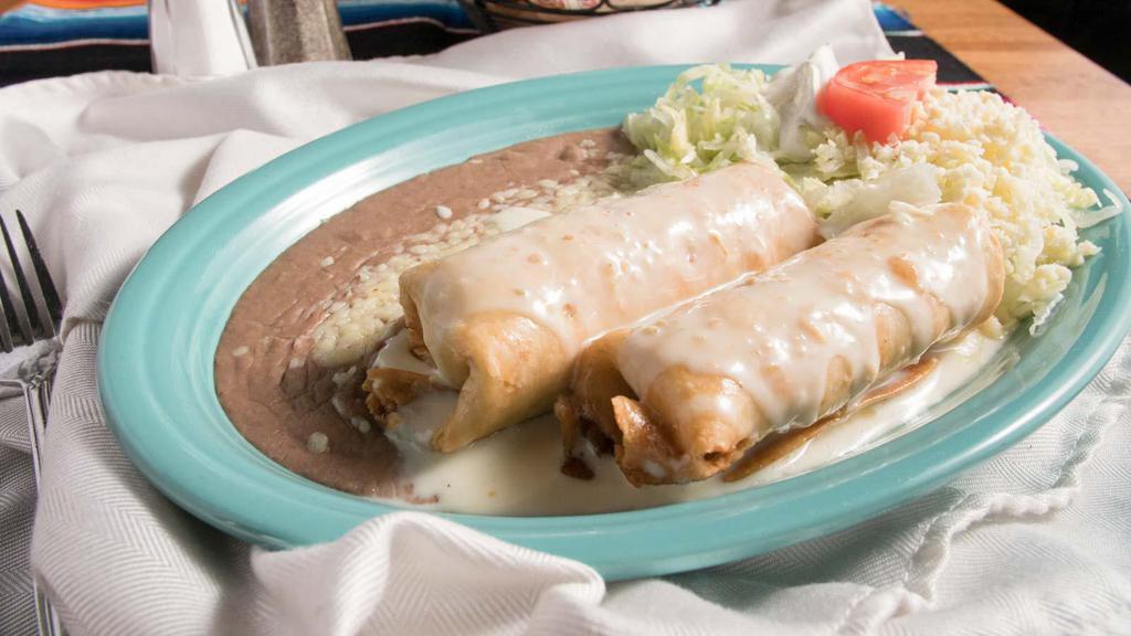Chimichanga · A flour tortilla deep fried filled with beans, shredded beef, or chicken topped with cheese dip, garnished with guacamole salad, and rice.