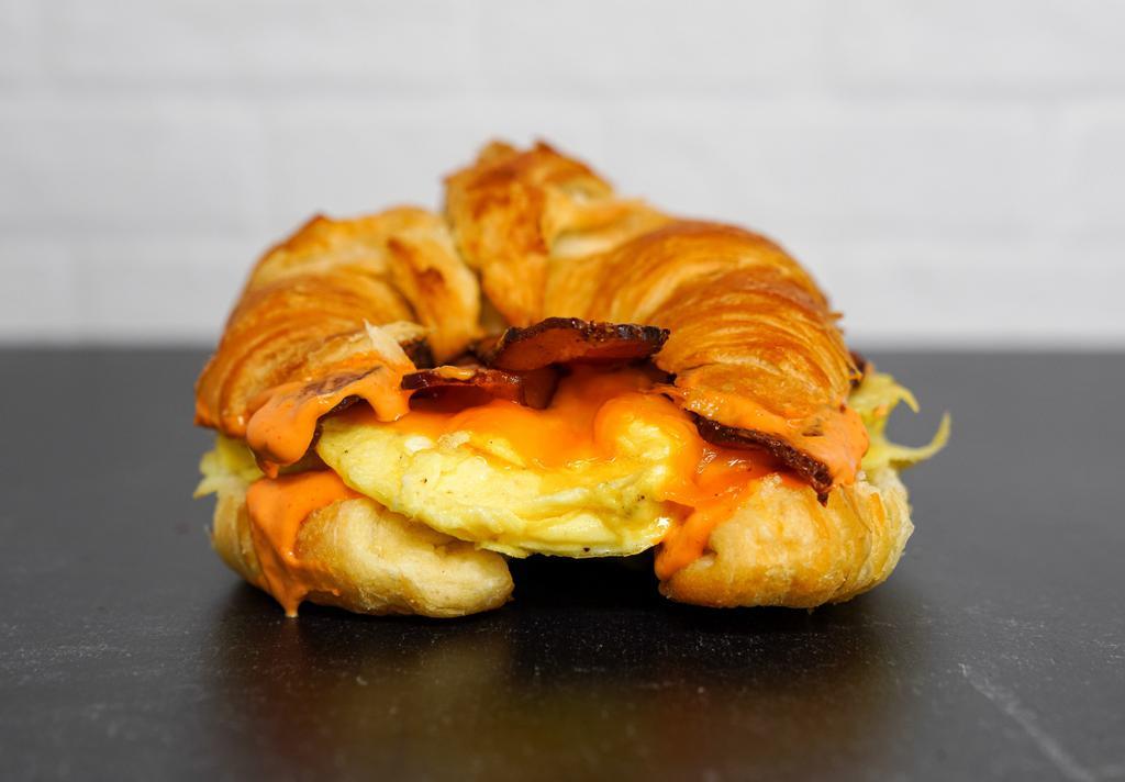 Croissant, Bacon, Egg, & Cheese Sandwich · 2 scrambled eggs, melted cheese, smoked bacon, and Sriracha aioli on a warm croissant.