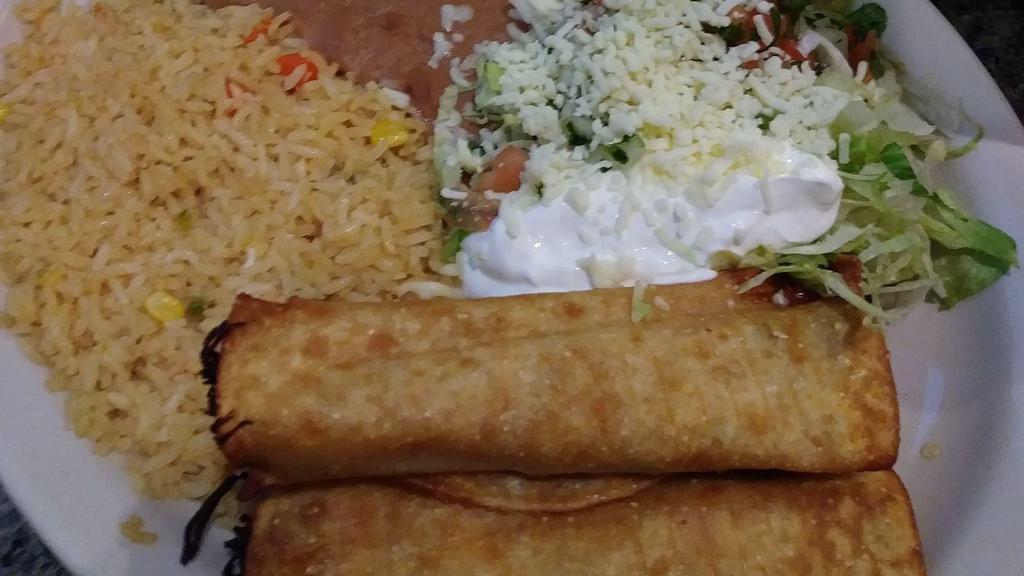 Flautas  · Two flute-like tacos fried, filled with shredded chicken.  Topped with lettuce, guacamole and sour cream.  Served with rice and beans.