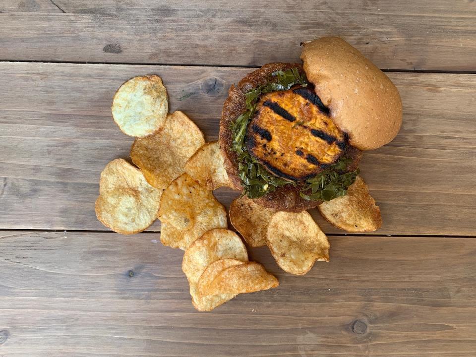 Black Eye Pea Burger · Black Eyed Pea patty topped with a oven roasted sweet potato slice, pickled collard greens, and sriracha aioli on a lightly toasted wheat bun.