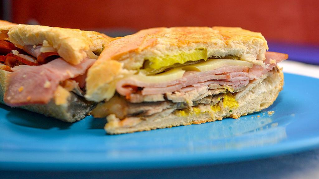 Cuban · A traditional Cuban sandwich made on authentic Cuban bread. Made with sliced roasted pork, sliced ham, swiss cheese, pickles, and mustard. This sandwich is served hot and pressed.