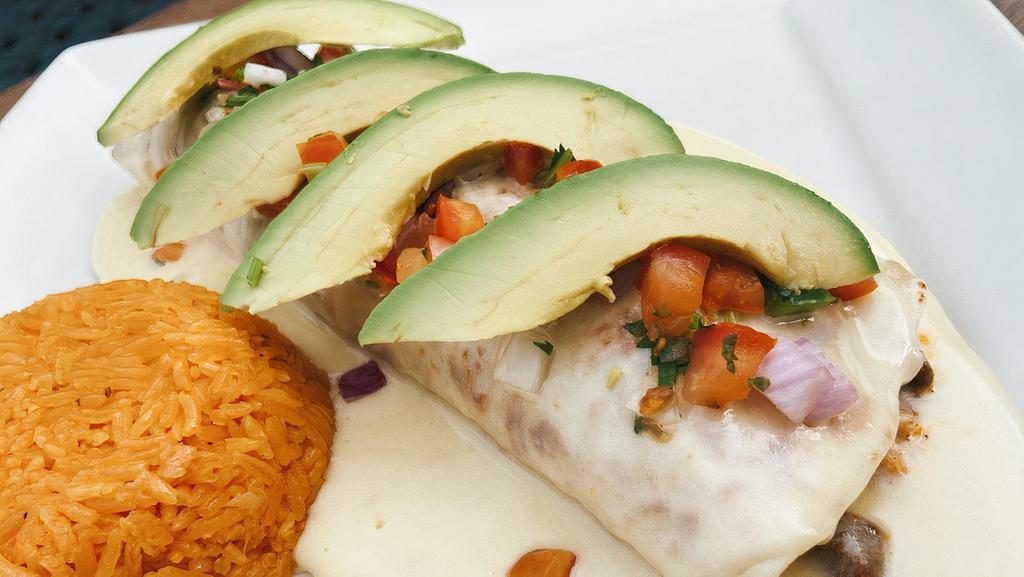 Burrito Vaquero · Tortilla filled with grilled chicken, steak, chorizo, and beans, topped with cheese dip, avocado and pico de gallo. Served with rice.