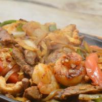 Texas Fajitas · Tender beef, chicken, and shrimp cooked with onions, tomatoes, and bell peppers. Served with...