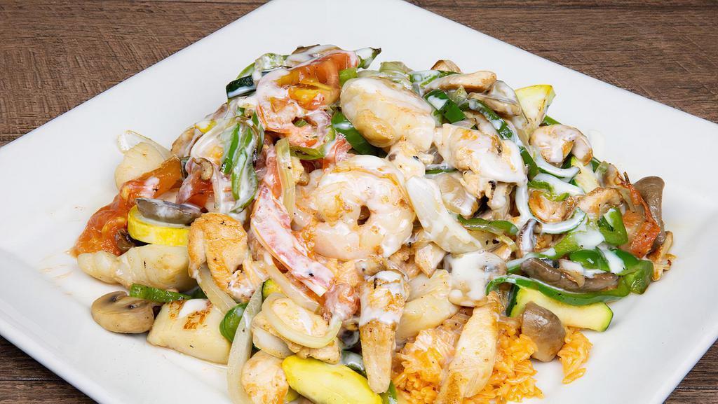 Tierra Y Mar · Grilled shrimp, scallops and chicken, bell peppers, onions, tomatoes, squash, zucchini, and mushrooms, served on a bed of rice and topped with cheese dip.