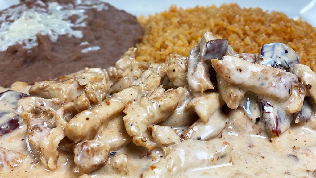 Chicken Chipotle · Sliced grilled chicken in a mild chipotle cheese sauce. Served with rice, beans with cheese, and tortillas.