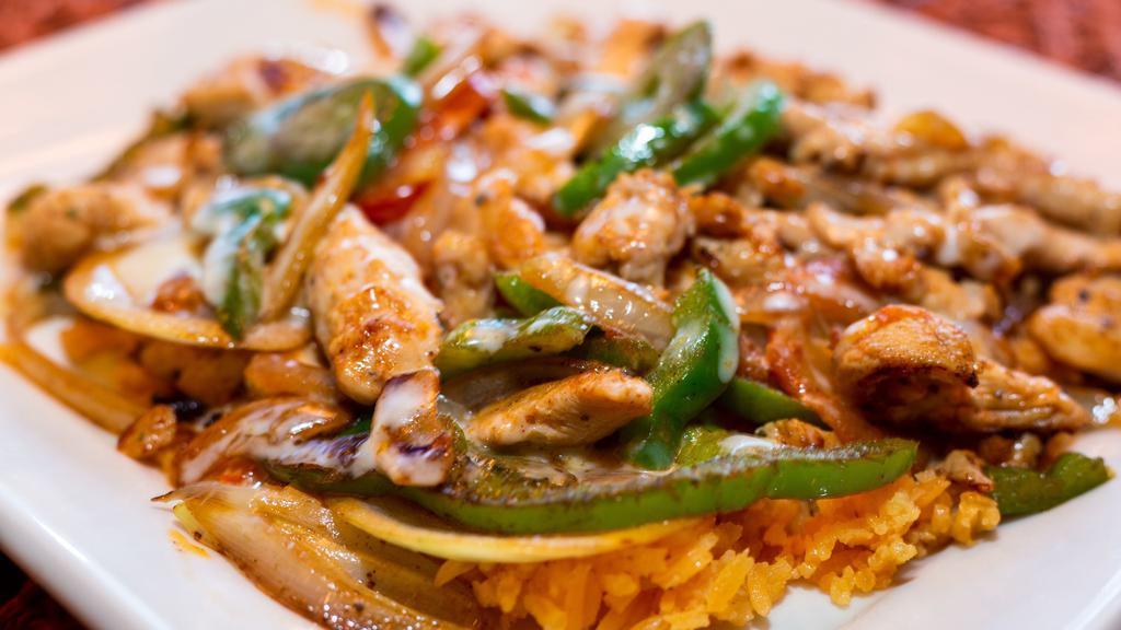 Pelusa Lunch · A lunch plate of Mexican rice topped with grilled chicken, peppers, corn, onions, tomatoes, and cheese dip.